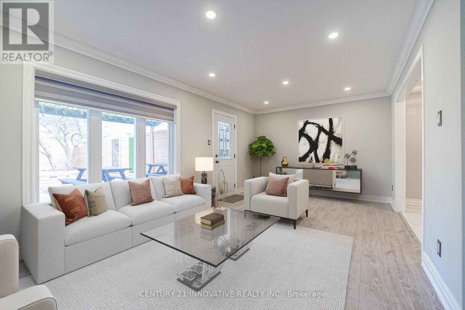 A modern living room with a glass coffee table and white furniture.