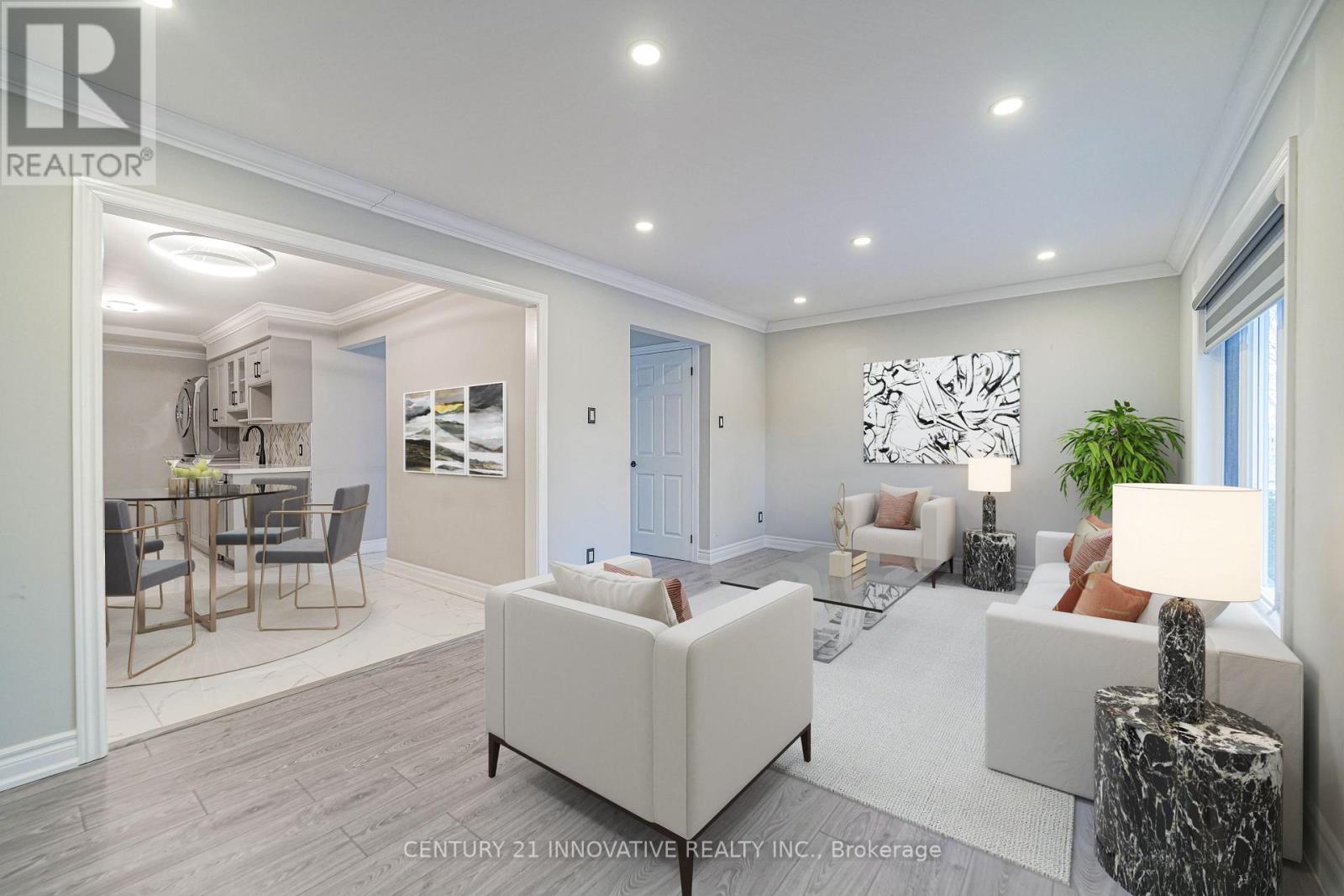 A well-lit living room with a white sofa set and a grey rug.