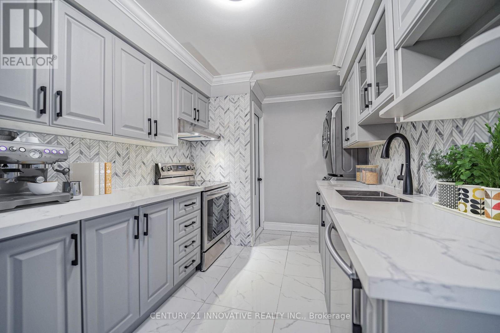 A kitchen with white cabinets and a marble countertop.