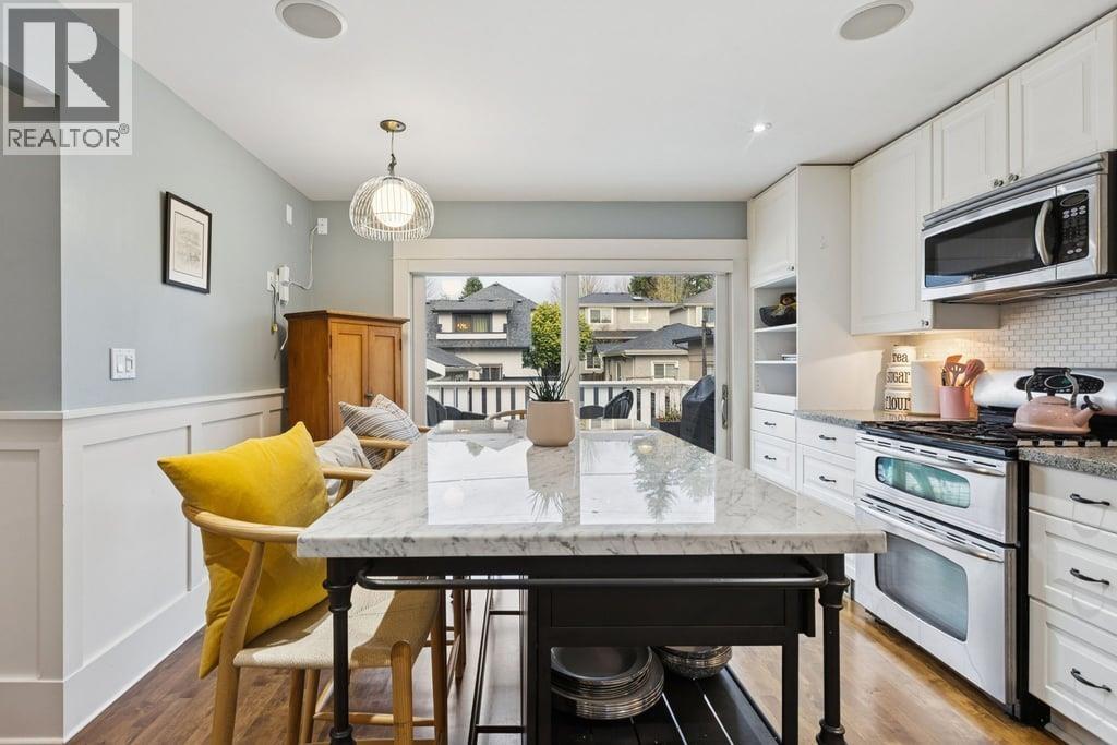 A kitchen with a table and chairs in front of a window.