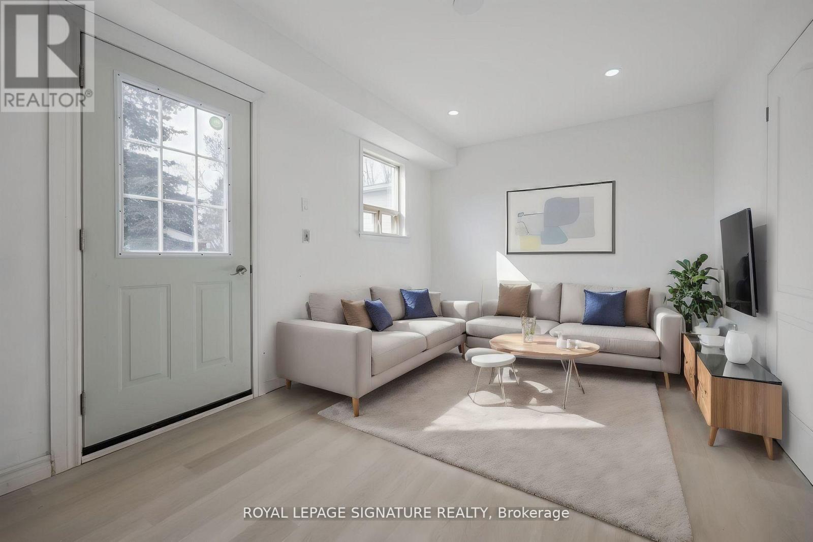 A living room with a couch, a coffee table, and a flat screen TV.