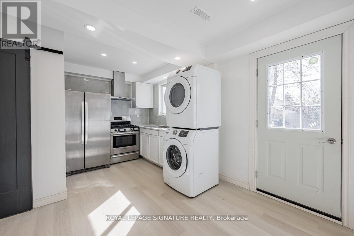 A white washing machine is in a clean, empty room.