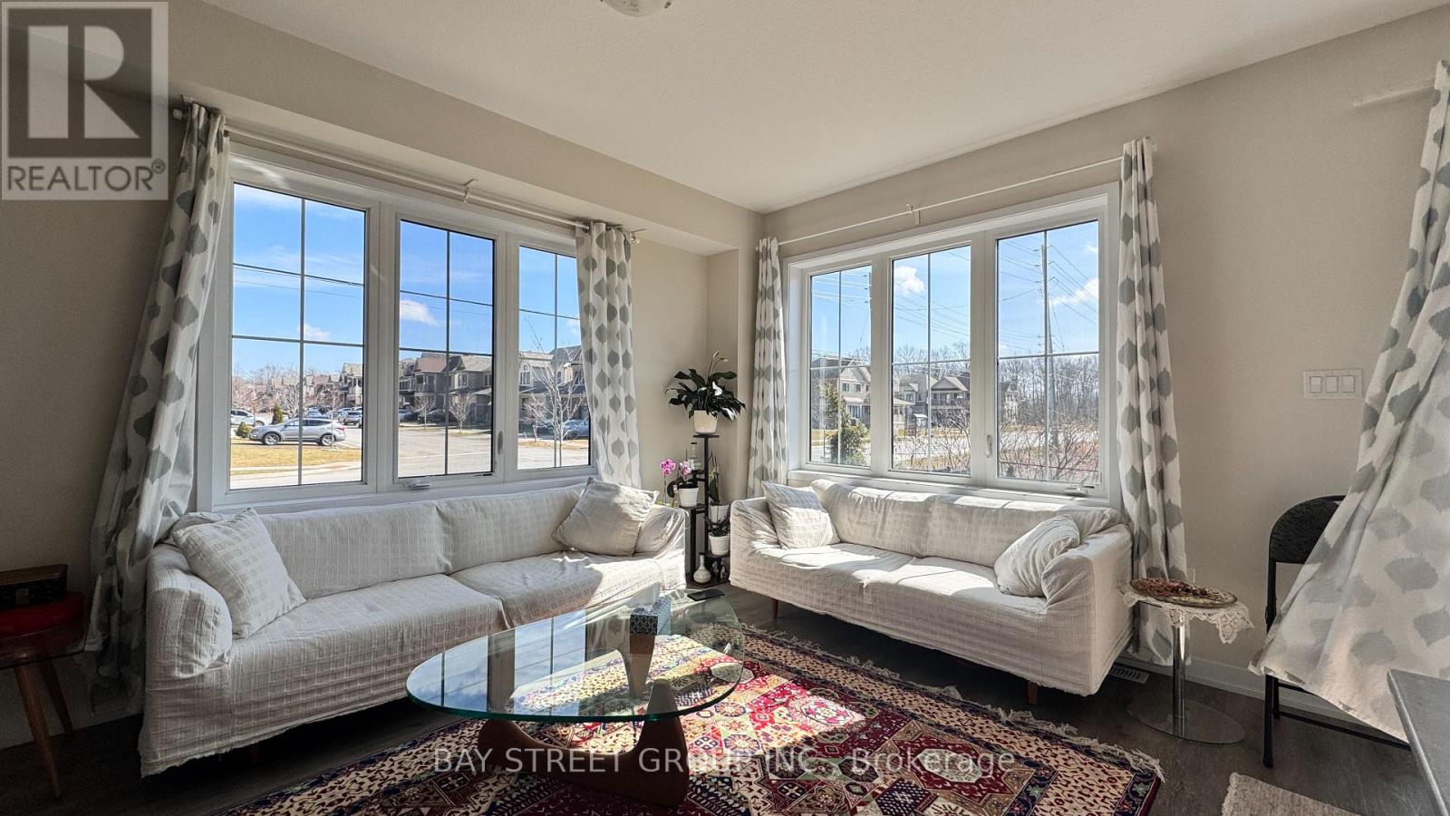 A living room with a couch, a chair, a coffee table, and a window with curtains.