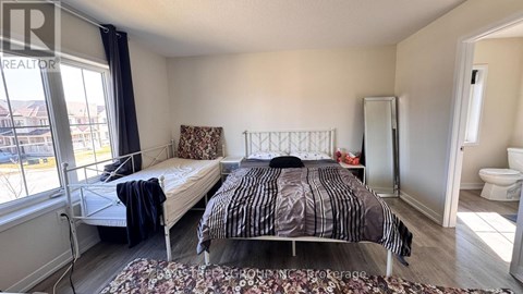 A bedroom with a bed and a window overlooking a cityscape.