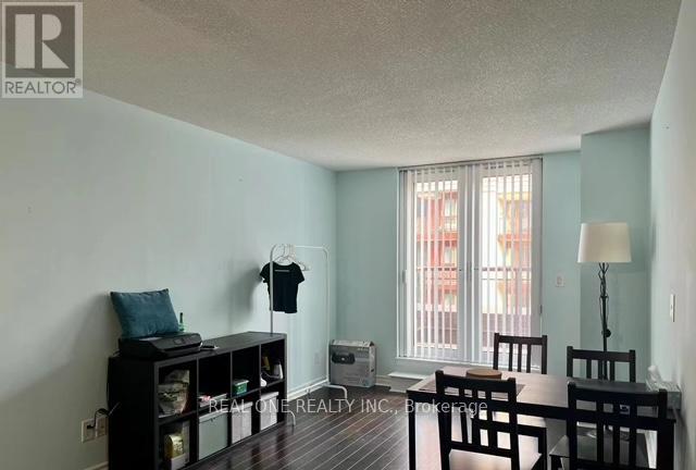 A room with a table and chairs, a bookshelf, and a window with curtains.