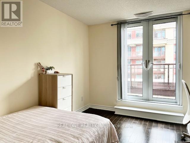 A bedroom with a bed, nightstand, and window.