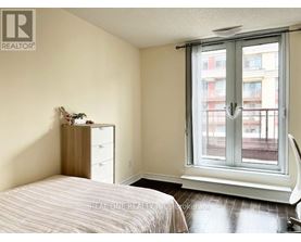 A bedroom with a bed, nightstand, and window.