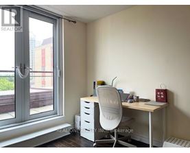 A room with a desk, chair, and window.