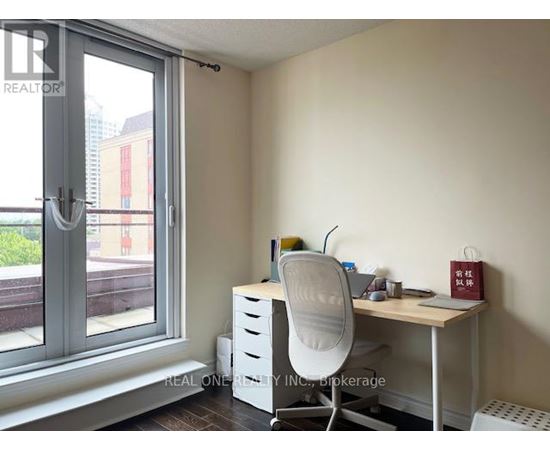 A room with a desk, chair, and window.