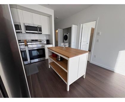 A kitchen with a wooden island and stainless steel appliances.