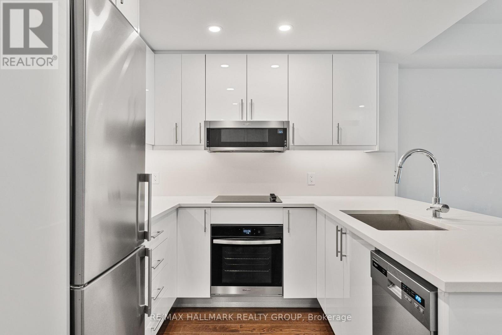 A modern kitchen with white cabinets and stainless steel appliances.