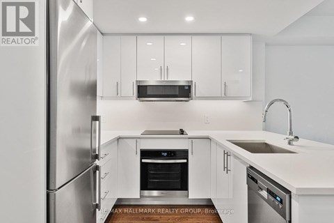 A modern kitchen with white cabinets and stainless steel appliances.