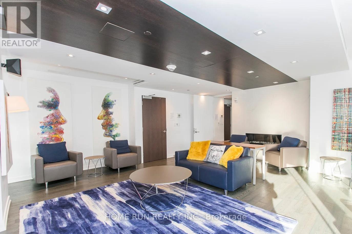 A living room with a blue rug and a sofa.