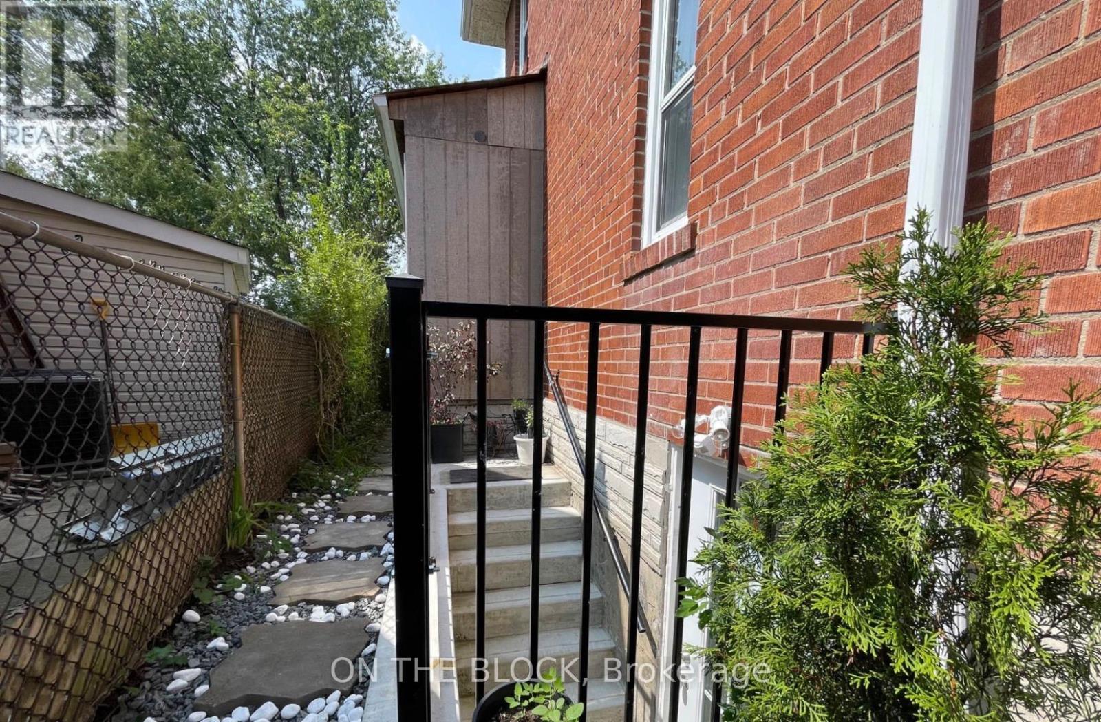 A black metal fence surrounds a brick building.
