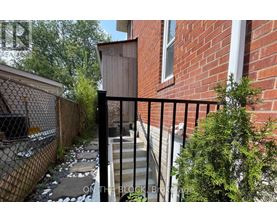 A black metal fence surrounds a brick building.