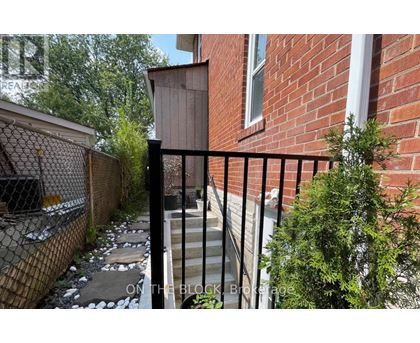 A black metal fence surrounds a brick building.