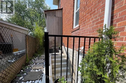 A black metal fence surrounds a brick building.