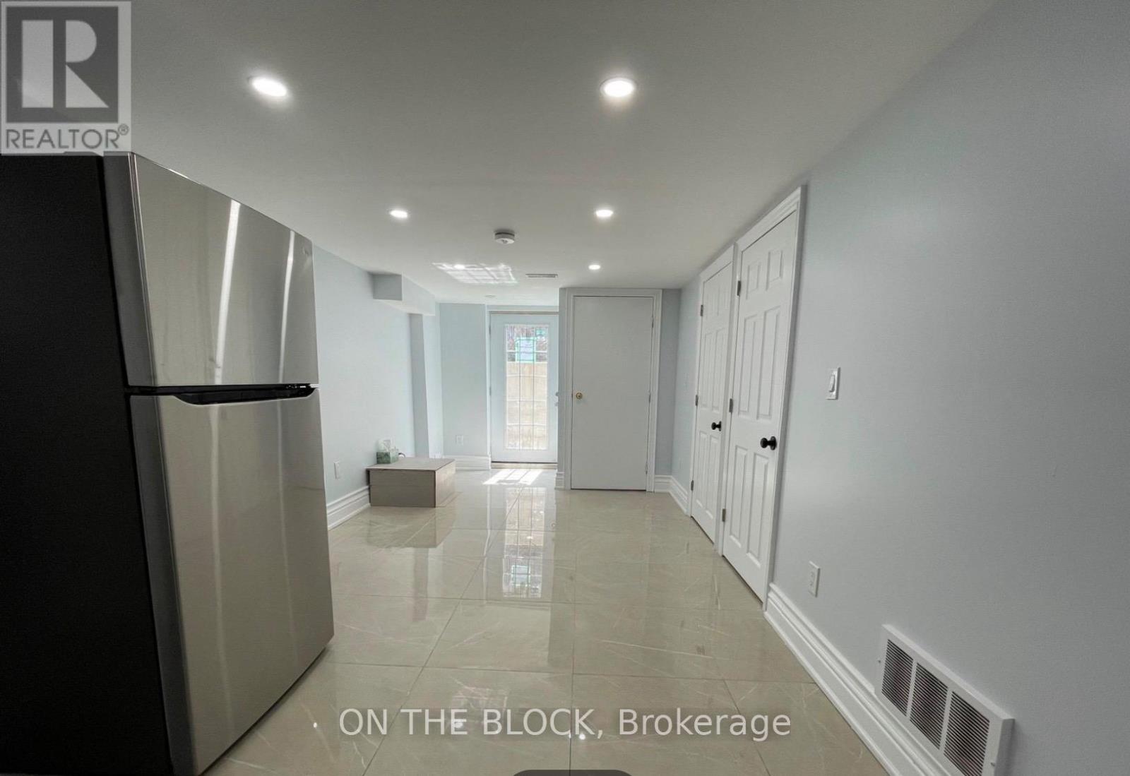 A spacious kitchen with a refrigerator and a dining area with a table and chairs.