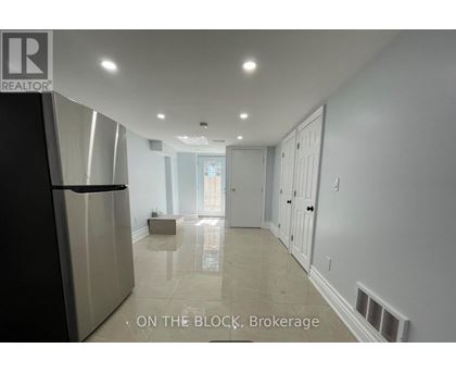 A spacious kitchen with a refrigerator and a dining area with a table and chairs.