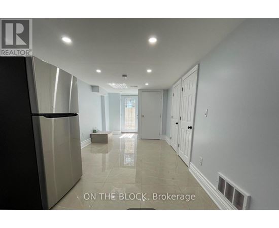 A spacious kitchen with a refrigerator and a dining area with a table and chairs.