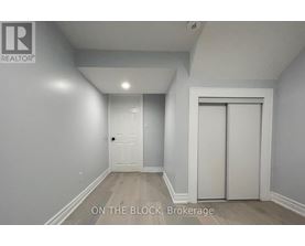 A brokerage sign is on the wall in a white room.