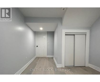 A brokerage sign is on the wall in a white room.