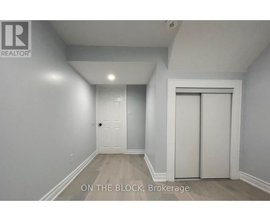 A brokerage sign is on the wall in a white room.