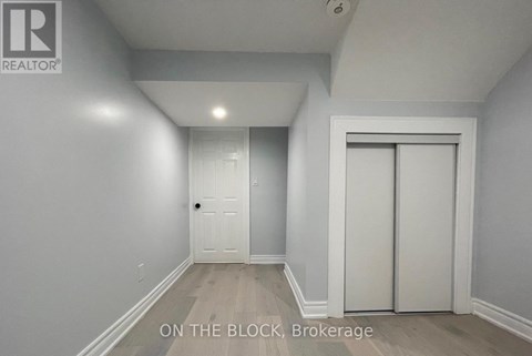 A brokerage sign is on the wall in a white room.