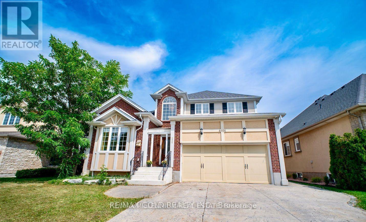 A large, two-story house with a garage is for sale.
