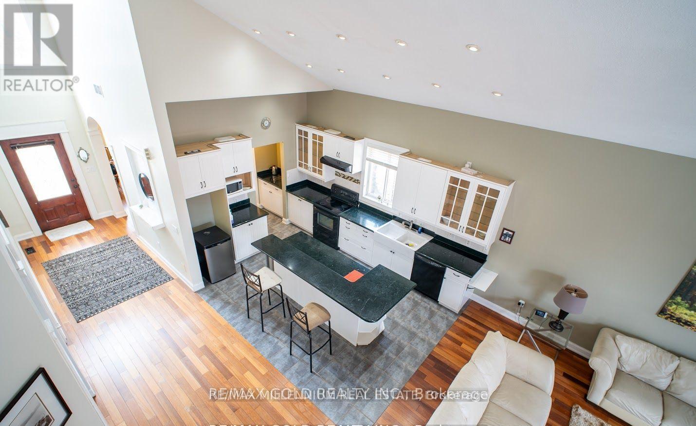A well-lit open plan living and kitchen area with a dining table and chairs.