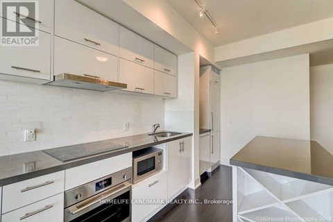 A kitchen with white cabinets and a stainless steel counter.