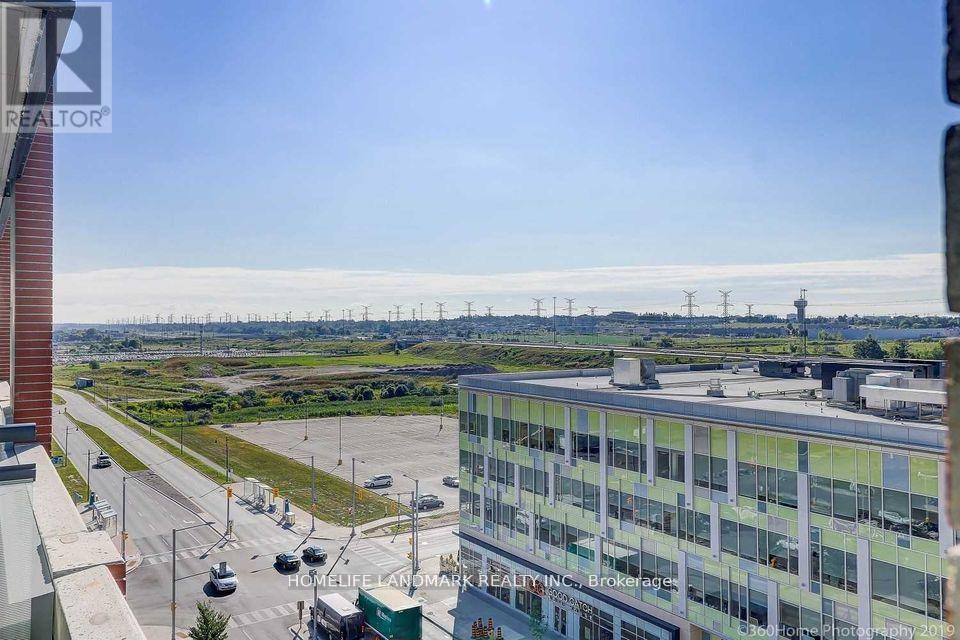 A view from a high-rise building looking out over a parking lot and a distant landscape.
