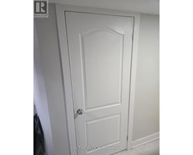 A white door with a black handle and a brokerage logo on the top left.