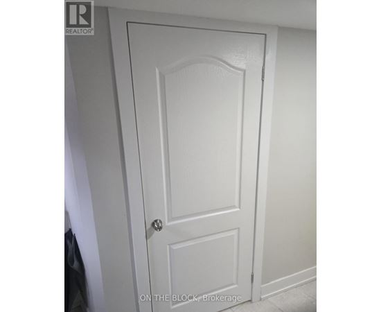 A white door with a black handle and a brokerage logo on the top left.
