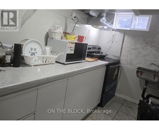 A kitchen counter with a white fridge and a black dishwasher.