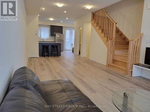 A living room with a couch and a staircase.