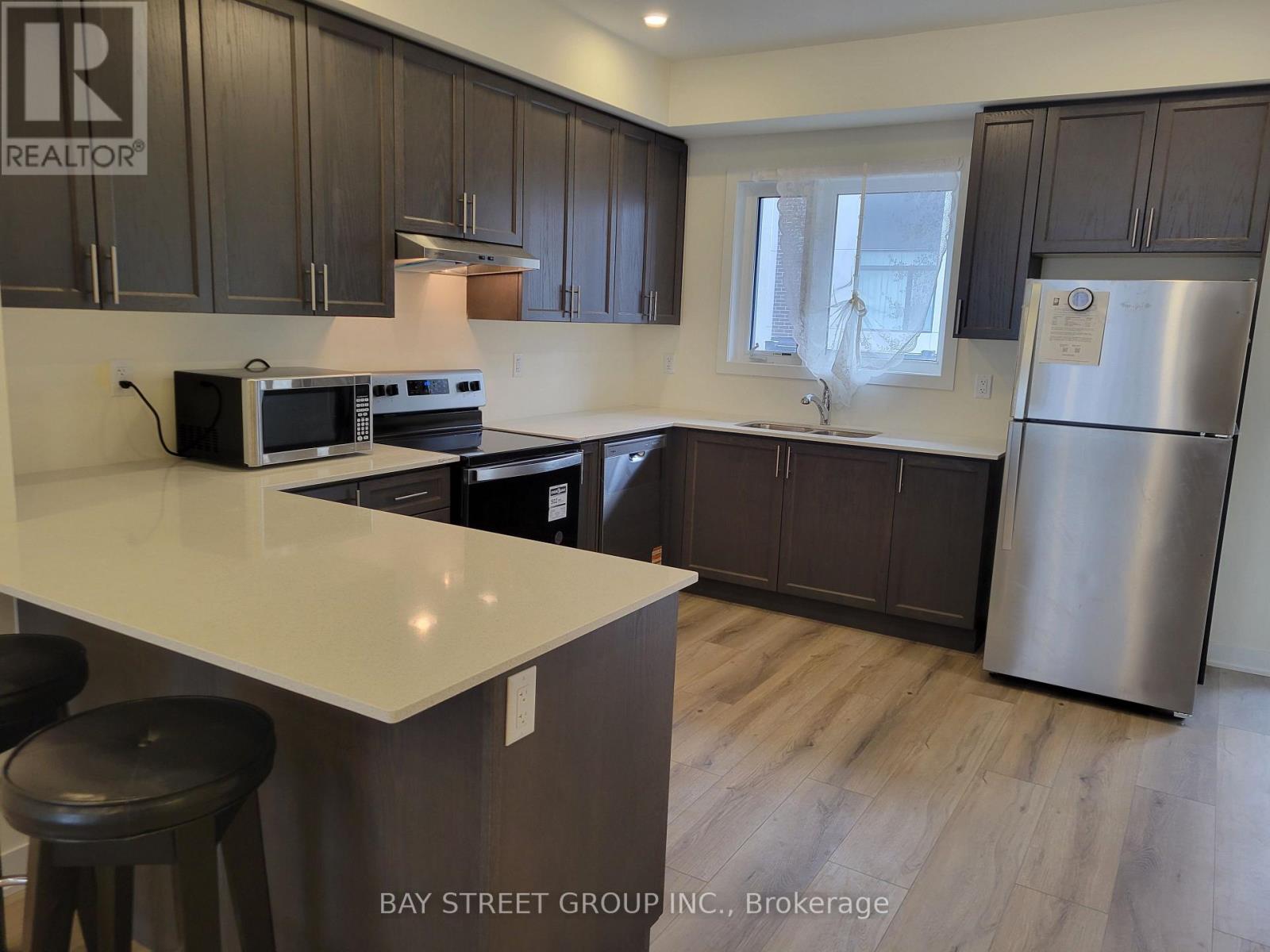A kitchen with a white counter top and a refrigerator.