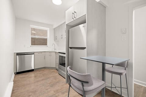 A kitchen with a table and chairs.