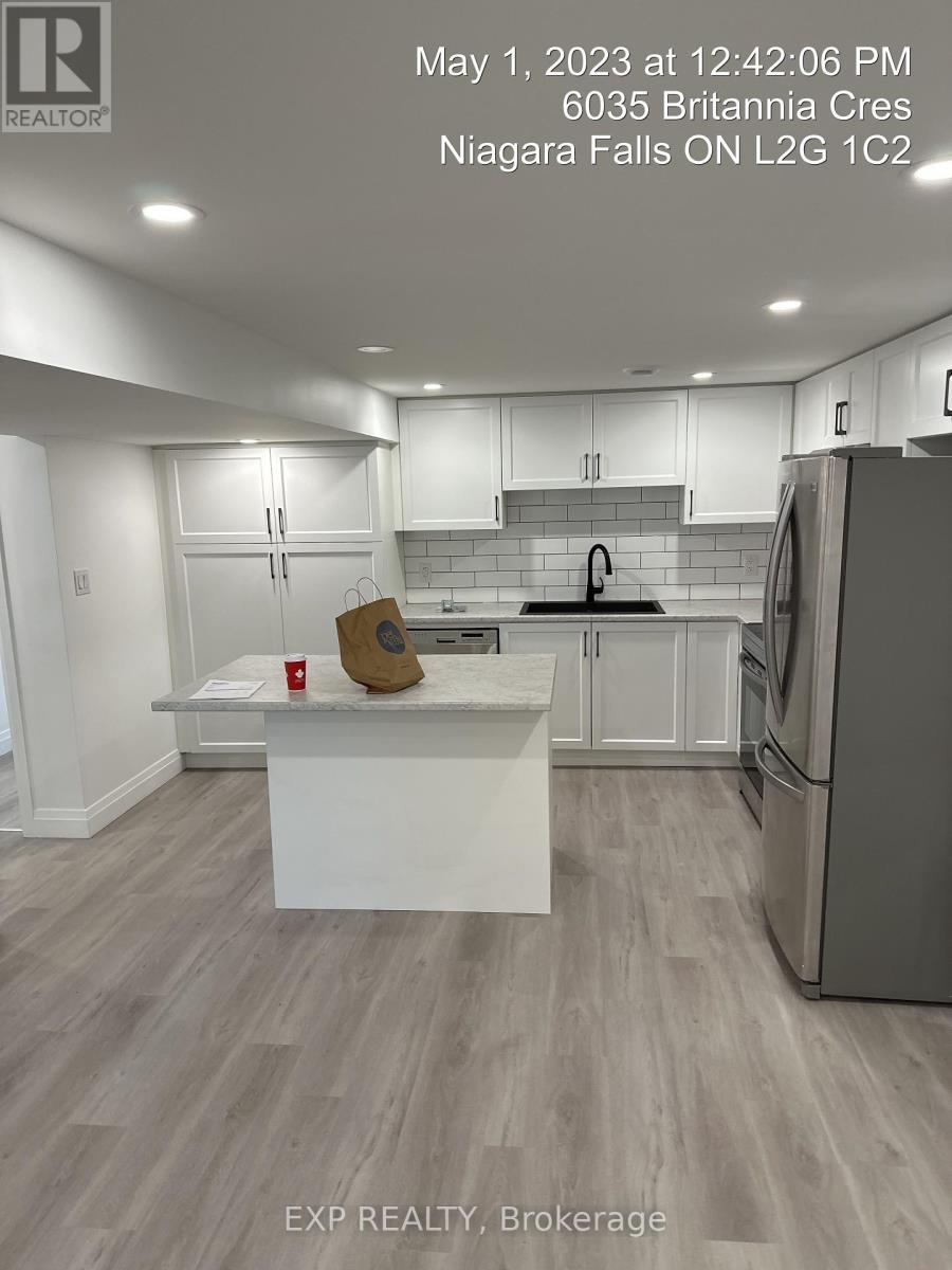 A kitchen with a white island and a refrigerator.
