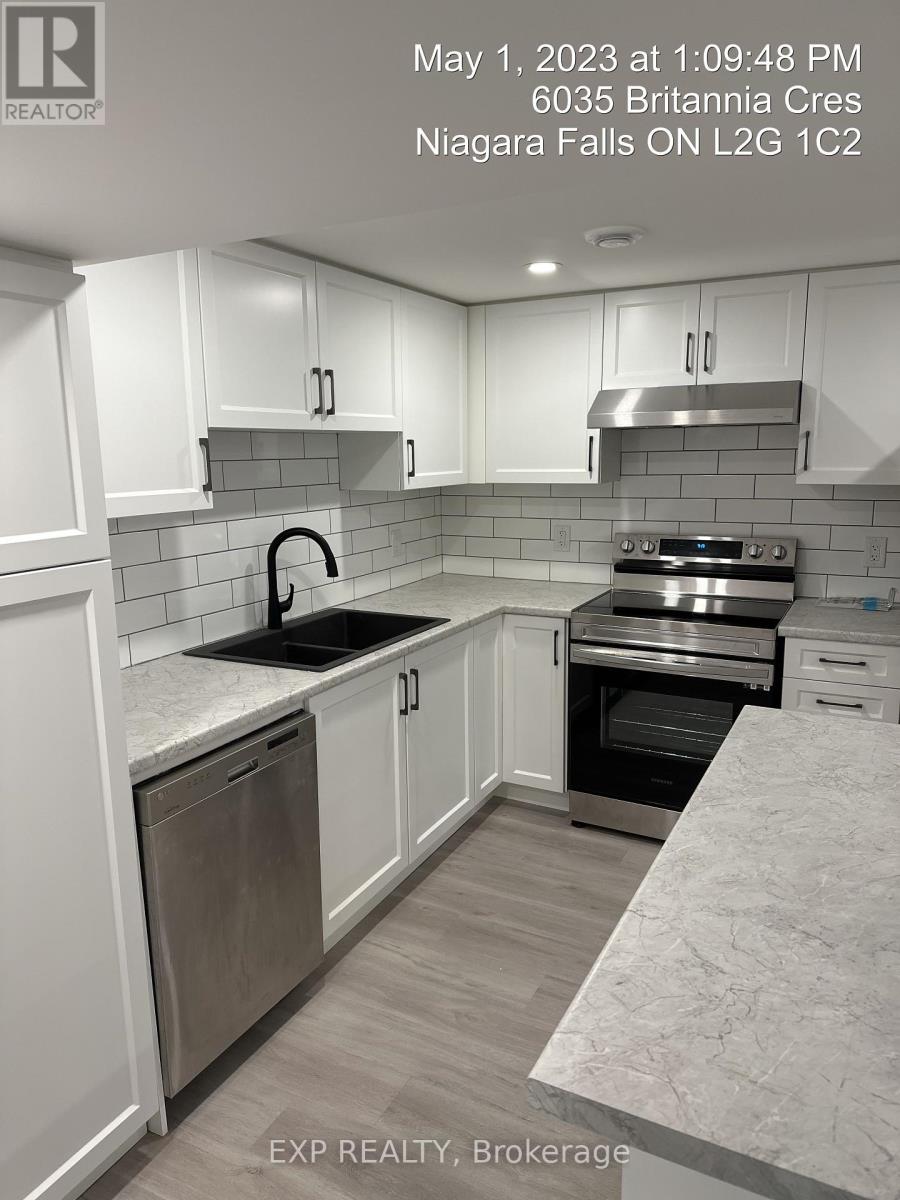 A kitchen with white cabinets and a marble countertop.