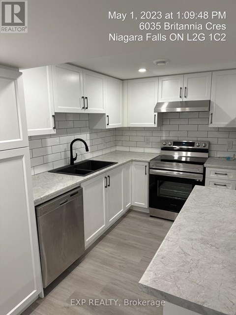 A kitchen with white cabinets and a marble countertop.