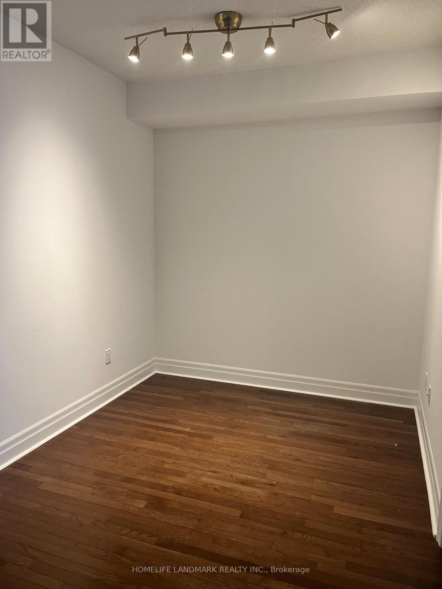 A room with wooden flooring and a white wall.
