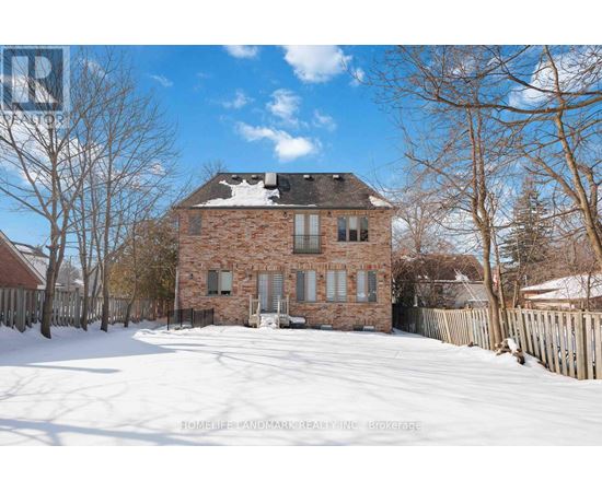 A brick house with snow on the ground and trees around it.