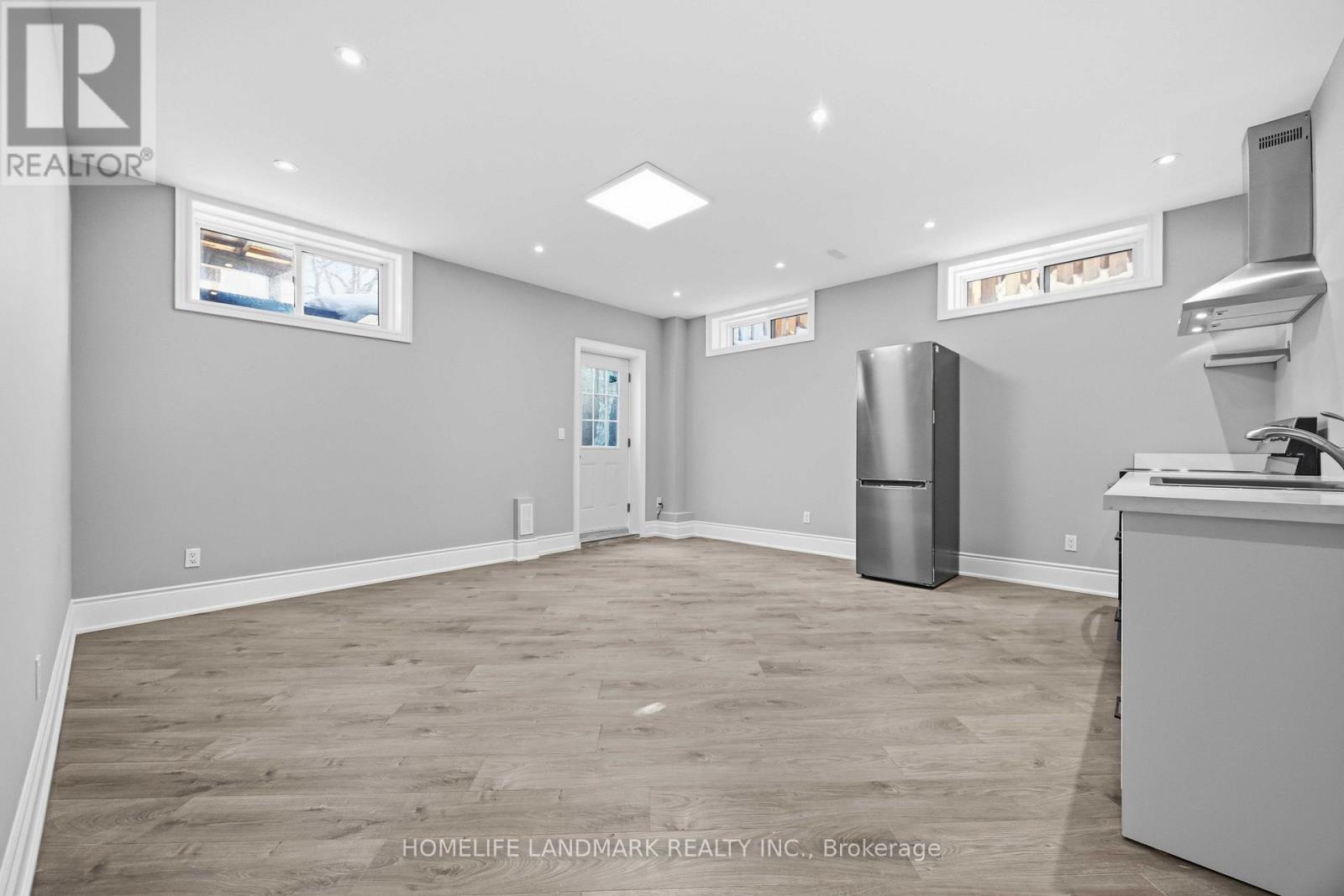 A spacious room with a grey floor and white walls.