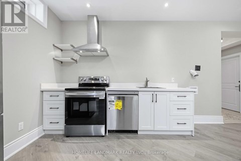 A kitchen with a stainless steel oven and white cabinets.