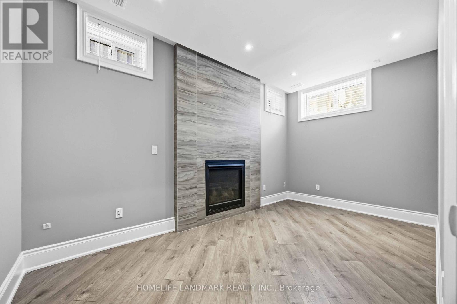 A living room with a fireplace and wood flooring.