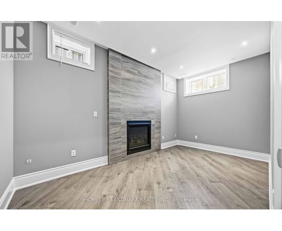 A living room with a fireplace and wood flooring.