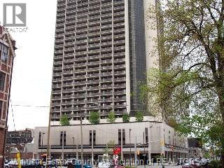A tall building with many windows is in the background.