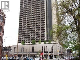 A tall building with many windows is in the background.