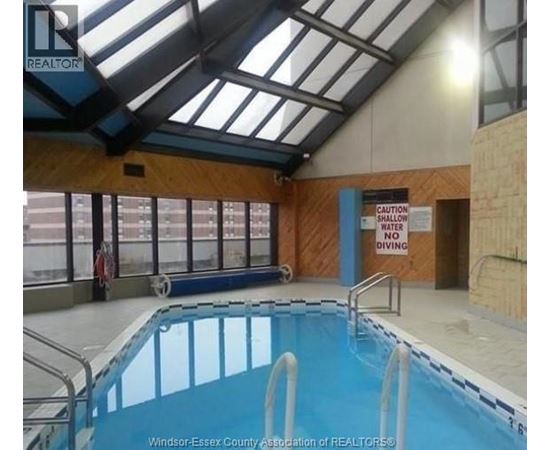 A pool with a sign that says "Caution Water Shallow No Diving".